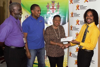 The Honourable Olivia Grange, Minister of Culture, Gender, Entertainment and Sport presenting a cheque for $500,000 to Andre Whitter, Acting President, Deaf Sports Jamaica (right), on Friday (December 1) at her offices in Kingston. The contribution will assist in covering the expenses for a Football School Competition which involve five High Schools and two Primary Schools for the Deaf. The competition will take place December 8 and 9, 2017 at the University of Technology. Also pictured are: Denzil Wilks, General Manager, Sports Development Foundation and Nevell Aiken, Treasurer, Deaf Sports Jamaica (from left).