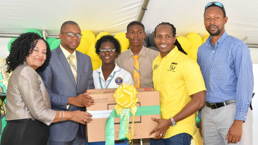 Minister of State in the Ministry of Culture, Gender, Entertainment and Sport, the Honourable Alando Terrelonge (second right), presents desktop computers to Principal of the Guy’s Hill High School in St. Catherine, Cecil Donald (second left), at a ceremony held at the Jamaica Anti-Doping Commission offices on Ballater Avenue in St. Andrew, on February 1.  Others (from left) are JADCO’s Executive Director, June Spencer Jarrett; students at the school, Ajoni Murphy and Shanique Neil, and the institution’s Coach, Andrew-Hugh Murphy.