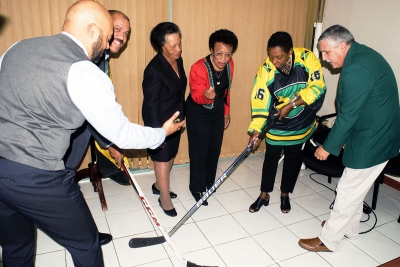 Poke checking. The Honourable Olivia Grange, Minister of Culture, Gender, Entertainment and Sport prepares to poke the puck away from Greame Townsend, National Hockey Coach (2nd left) as it is being released by Donovan Tait, hockey player and coach (left). Looking on in anticipation are: Dorothy McLeod, Director, California Cultural Alliance (3rd left); founding members of the Jamaica Olympic Ice Hockey Federation Judith Smith (4th left) and Lester Griffin (right). The Jamaica Olympic Ice Hockey Federation and representatives from Tropical Ice Ventures of Canada paid a Courtesy Call on the Minister today (December 1) at her offices in Kingston.