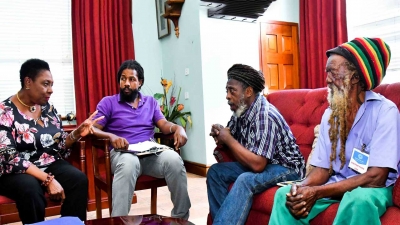 The Minister of Culture, Gender, Entertainment and Sport, the Honourable Olivia Grange (left) in discussion with Coral Gardens Incident Survivor, Ras Walter Brissett (right) and members of Rastafari Coral Gardens Benevolent Society (l-r) Ras Gregory Taylor, Chairman; and Ras Samuel Brown, Treasurer in Montego Bay, St James in July 2019.