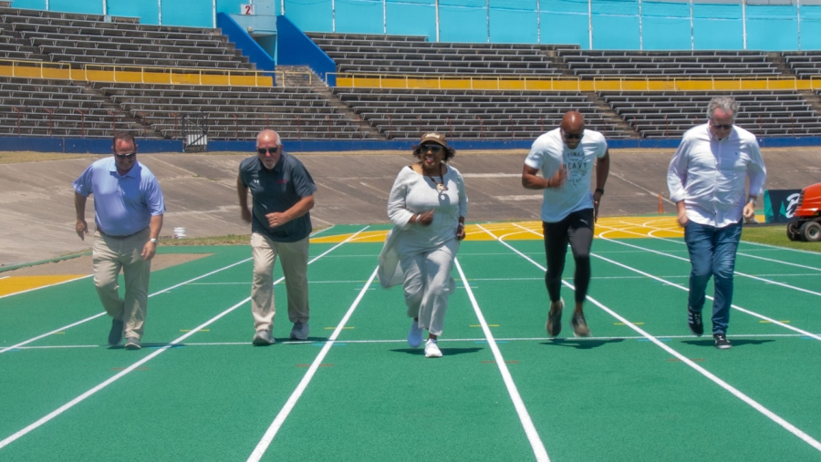 The Minister of Culture, Gender, Entertainment and Sport, the Honourable Olivia Grange (centre) in a race on the new running track at the National Stadium with (from left) Tim Jordan and Doug Stone both of Rekortan; the former world 100 metres record holder Asafa Powell; and Grand Slam Track Venue Director, Don Lockerbie.