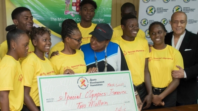 The Minister of Culture, Gender, Entertainment and Sport, the Honourable Olivia Grange (centre) interacts with members of Jamaica&#039;s team to the 2019 Special Olympics World Games after presenting a cheque for J$2M to assist with expenses.  Also pictured is Ali McNab, Chairman of Special Olympics Jamaica.