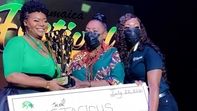 The Minister of Culture, Gender, Entertainment and Sport, the Honourable Olivia Grange, presents Jamaica Festival Song winner, Stacious, with trophy.