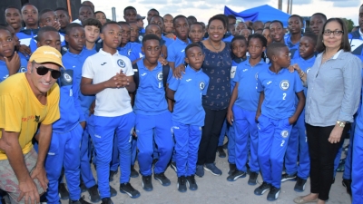 Minister of Culture, Gender, Entertainment and Sport, the Honourable Olivia Grange and the Minister of Labour and Social Security and Member of Parliament for North East St Ann, the Honourable Shahine Robinson (right) with Peter Gould, owner of Mount Pleasant Academy (left) and students at the Drax Hall Sports Complex in St Ann.