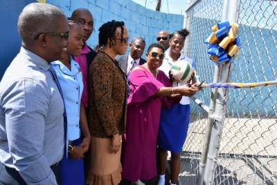 The Honourable Olivia Grange, Minister of Culture, Gender, Entertainment and Sport cuts the ribbon to signal the official opening of the netball court at the Gaynstead High School. Looking on are: Fabian Brown, Caretaker, Trafalgar Division; Kelsey Jonas, netballer; Pastor Derrick Brown, Board Member, Gaynstead High School, Dr. J. Boyd-Vassell, Principal, Liston Aiken, Vice Principal; Major Clifton Lumsden, Chairman, School Board and Latonya Williams, netballer.