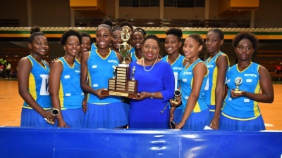 Minister of  Culture, Gender, Entertainment and Sport, the Honourable Olivia Grange, holds the trophy with her alma mater, Gaynstead High School the new senior and junior ISSA Urban Area Netball champions 