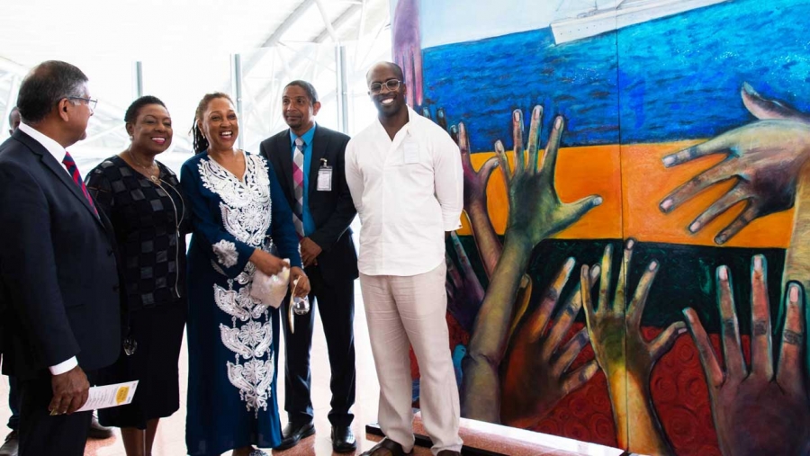 The Minister of Culture, Gender, Entertainment and Sport, the Honourable Olivia Grange (second left) shares a light moment with artist, Rosemarie Chung (centre) at the Unveiling of the Windrush Mural Exhibition at the Norman Manley International Airport on Thursday, 29 August 2019. Sharing the moment are: the British High Commissioner, His Excellency Asif Ahmad (left); The Mayor of Kingston, His Worship Senator Councillor Delroy Williams (second right); and Chief Curator at the National Gallery of Jamaica, O&#039;Neil Lawrence (right).