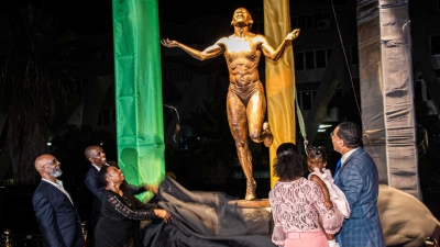 Prime Minister, the Most Honourable Andrew Holness (right); Olympic sprint champion Veronica Campbell Brown and her daughter, Avianna (2nd right); the Minister of Culture, Gender, Entertainment and Sport, the Honourable Olivia Grange (3rd left); and Omar Brown, husband of Veronica (2nd left) participate in the unveiling of the statue in honour of Veronica Campbell Brown at the National Stadium on Sunday, 20 October 2019. Looking on is the sculptor, Basil Watson.