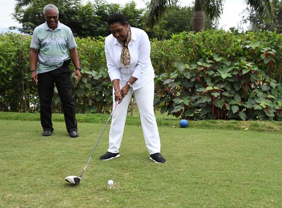 The Honourable Olivia Grange, Minister of Culture, Gender, Entertainment and Sport is all set to tee off. Looking on is Major Desmon Brown, Organiser of the Jamaica Professional Golf League Series. 