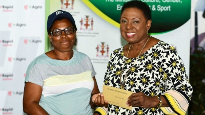 Minister of Culture, Gender, Entertainment and Sport, the Honourable Olivia Grange presents grant to Violet Morris-Peddie at the Ministry&#039;s Economic Opportunities Workshop in Accompong, St Elizabeth.  The Minister awarded 50 grants to small businesses to boost the cultural economy in Accompong.