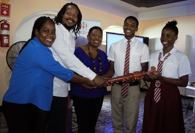 The Honourable Olivia Grange, Minister of Culture, Gender, Entertainment and Sport hands over the Reparations Baton to head boy Daneil Reid and head girl Renae Robinson of Paul Bogle High School (2nd r-l). Also photographed are: Lorraine Williams, teacher, Paul Bogle High School and Steven Golding, Chairperson of the Events/Outreach and Public Education Committee, National Council on Reparations. Tomorrow (October 19) students and young people will run with the Reparations Baton from Paul Bogle High School to the Old Courthouse where the Baton will be handed over to the Mayor after which the Rally will commence.