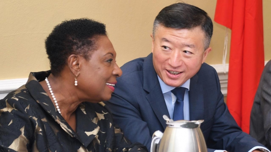 The Minister of Culture, Gender, Entertainment and Sport, the Honourable Olivia Grange (left) shares a light moment with the Ambassador of the People’s Republic of China to Jamaica, His Excellency Tian Qi.  They were at the official send-off for the second batch of 138 Jamaican athletes and coaches who will receive specialised training in China under a sports cooperation agreement between both countries.