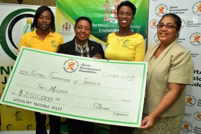 The Honourable Olivia Grange, Minister of Culture, Gender, Entertainment and Sport (2nd left) presents President, Netball Jamaica, Paula Daley-Morris (2nd right) with a cheque valued at J$2M towards the staging of the upcoming Sunshine Series. Also photographed are: Sunshine Girl, Shanice Beckford and Charmaine Hanson, Financial Controller, Sports Development Foundation (l-r).