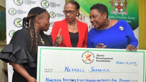 The Minister of Culture, Gender, Entertainment and Sport, the Honourable Olivia Grange (second left) hands over a cheque for 3.5 million dollars to the 1st Vice President of Netball Jamaica, Tricia Robinson (left) to assist with funding the Sunshine Girls for the 2019 World Cup in Liverpool.  Also photographed is Molly Rhone, President, International Netball Fedration.