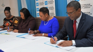 The Honourable Oliva Grange, Minister of Culture, Gender, Entertainment and Sport (second right); Robert Clarke, Group General Manager (Acting), Petroleum Corporation of Jamaica (right); Daffodil Thompson, Interim Executive Director, Jamaica Cultural Development Commission (second left) and Jody Grizzle, Project Manager, Energy Efficiency and Conservation Programme sign a Memorandum of Understanding. The MOU was signed between the the Petroleum Corporation of Jamaica and the Jamaica Cultural Development Commission, an agency of the Ministry of Culture, Gender, Entertainment and Sport.