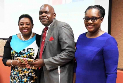 The Honourable Olivia Grange, Minister of Culture, Gender, Entertainment and Sport receives a copy of Senator Dr Floyd Morris’ (centre) autobiography, ‘By Faith, Not by Sight at the University of the West Indies (UWI) Regional Disability Studies Conference on March 13. The moment was shared with Christine Hendricks, Executive Director, Jamaica Council for Persons with Disabilities